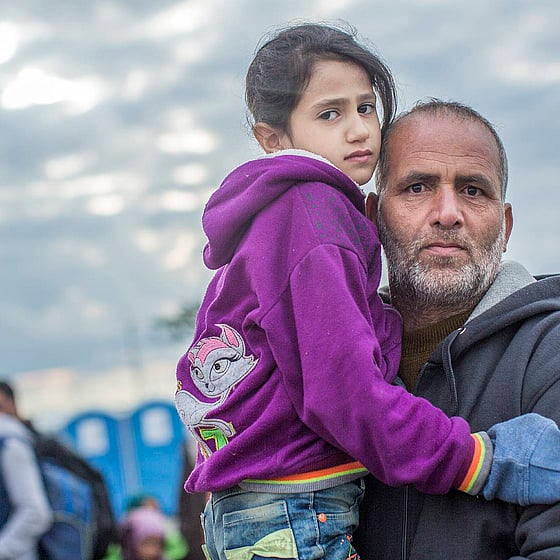 Man i beige vindjacka pratar i mobil