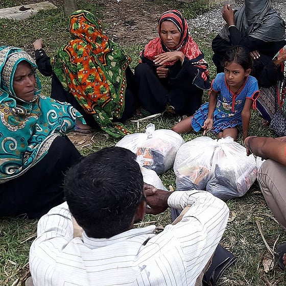 Volontär och kvinnor i Cox's Bazar sitter i cirkel