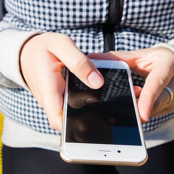 Händer som håller i en mobil