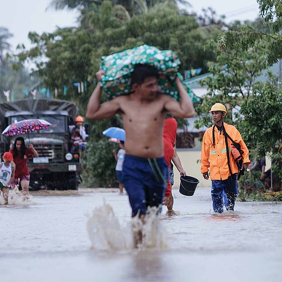 Människor på översvämmad gata efter extremväder