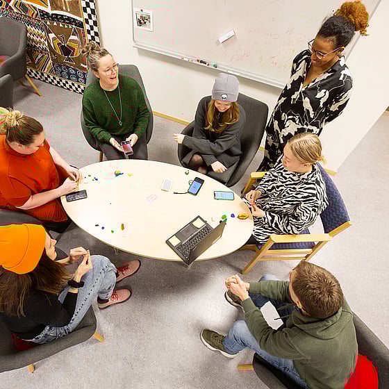 Elever vid Röda Korsets folkhögskola sitter runt ett bord.