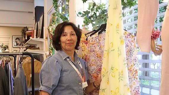 bild av Else som medverkar i artikeln tagen vid ett av skyltfönstren i butiken i Malmö. 