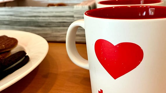En kopp kaffe står på ett bord tillsammans med kakor.