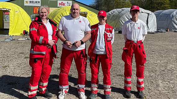 Fyra volontärer står med rödakorskläder.