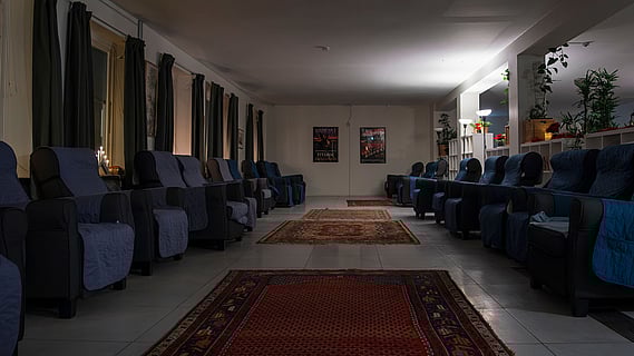 bild på malmös värmestuga, ett rum med fåtöljer längs sidorna och mattor i mitten 