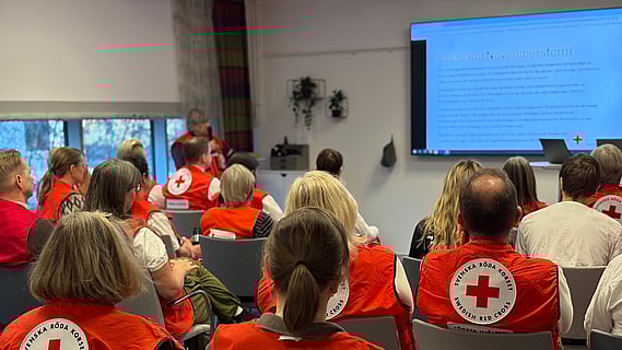 Personer i röda västar som lyssnar på genomgång