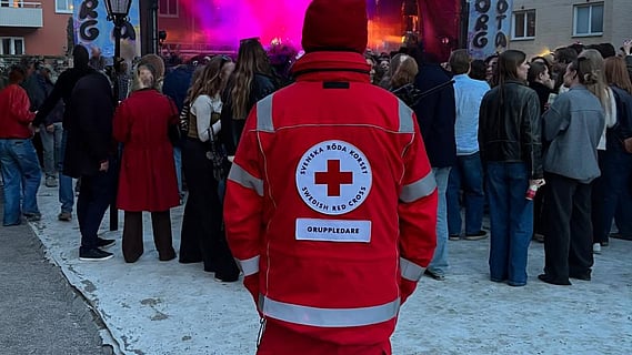En person med röd väst som tittar mot ett publikhav