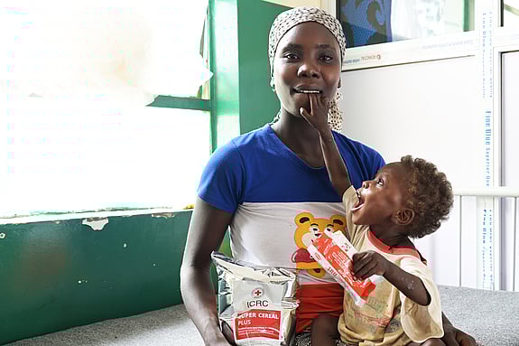 Sabina håller mamma Godiya i munnen.