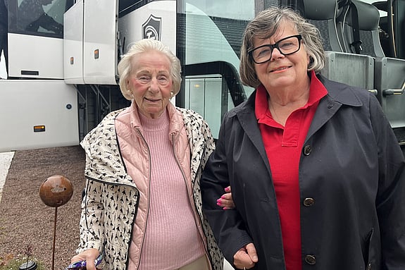 Vår sponsor Gunila Hammarberg och Ann Werthén från Röda Korset Habo utanför bussen. En pensionär hissas ombord på bussen från med hjälp av rullstolsrampen.