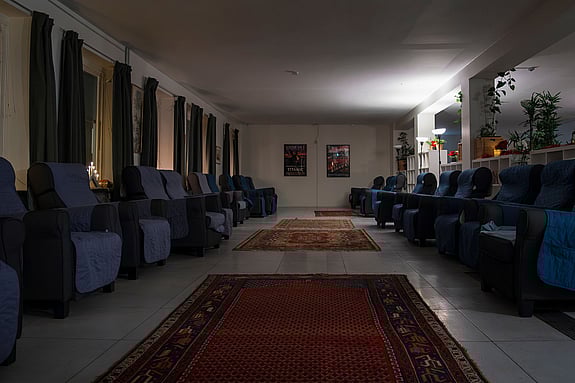 bild på malmös värmestuga, ett rum med fåtöljer längs sidorna och mattor i mitten