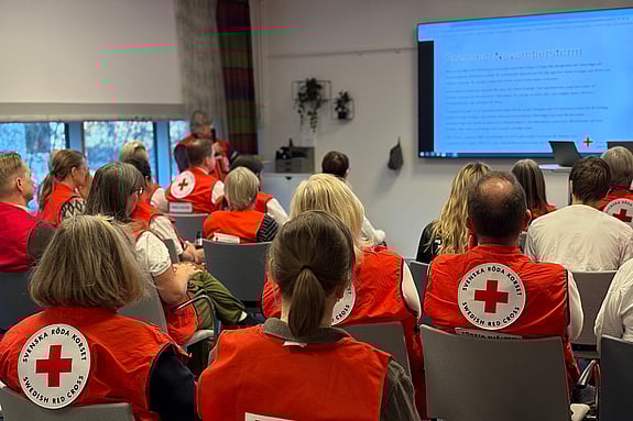 Personer i röda västar som lyssnar på genomgång