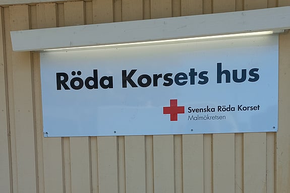 bild av gul husfasad med vit skylt där det står Röda Korsets hus 