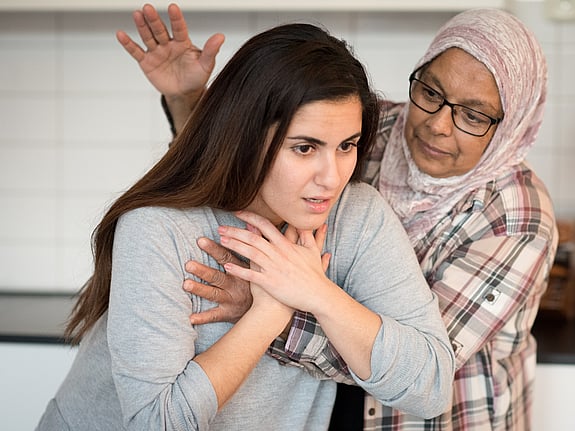 Kvinna har satt i halsen och får hjälp med första hjälpen vid luftvägsstopp