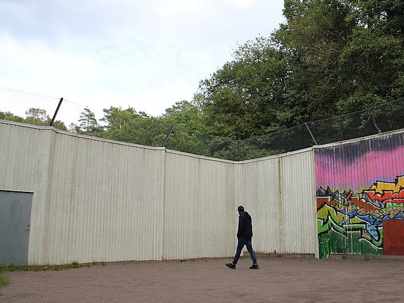 Ensam man går intill betongmur