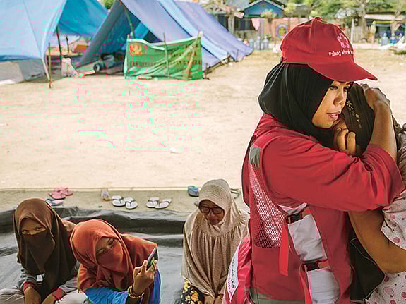 Volontär tröstar kvinna i kris.