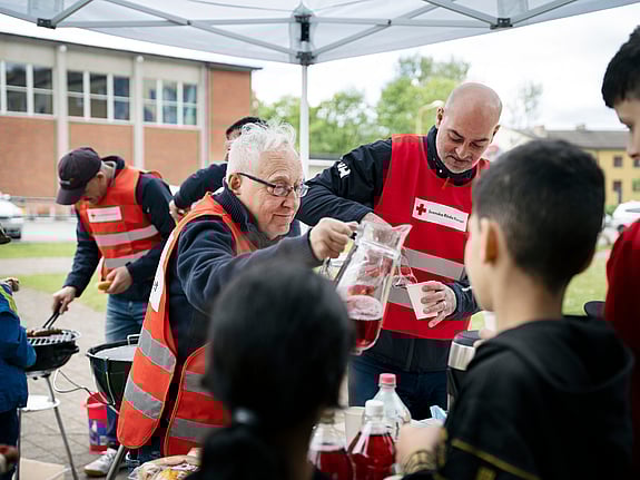 Sven-Erik Sjöstrand och Samir Makhlouf serverar korv och saft.