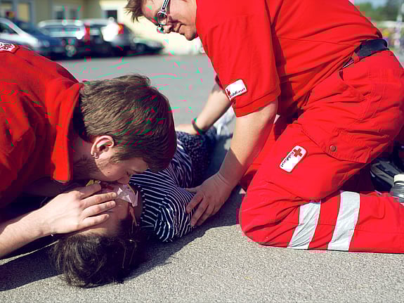 Första hjälpen-grupp har övning och hjälper en medvetslös person med hjärtlungräddning, HLR