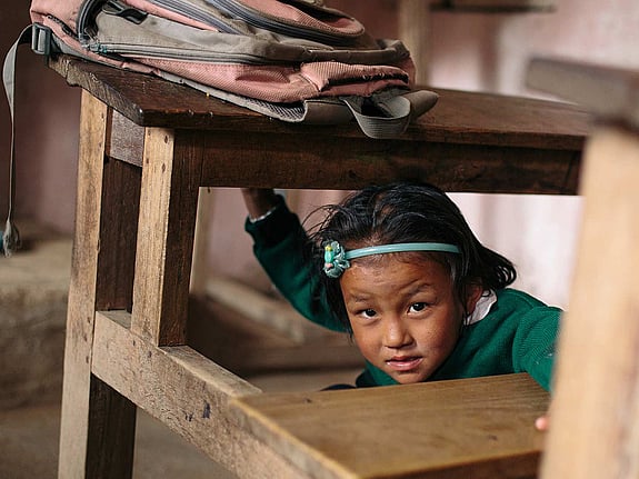 Flicka lär sig hur man skyddar sig vid en jordbävning