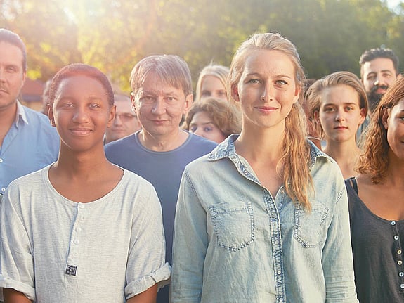 En stor grupp medlemmar tittar in i kameran.