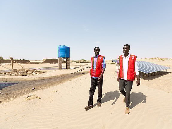 Två män går och pratar i ökenlandskap