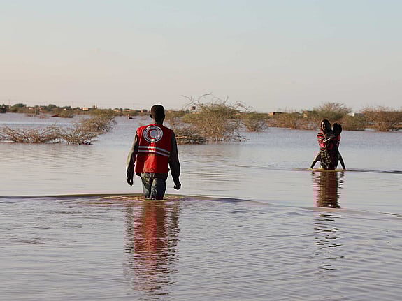 Människor som vadar efter översvämning