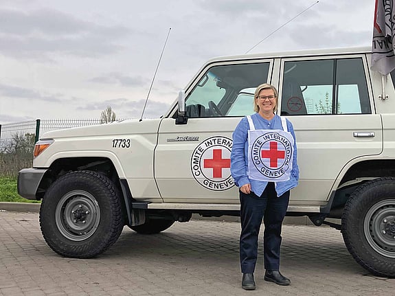 Karin Levenby bovy framför en bil från Röda Korset.