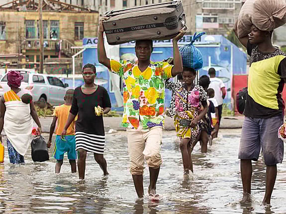 Människor flyr på översvämmad gata.