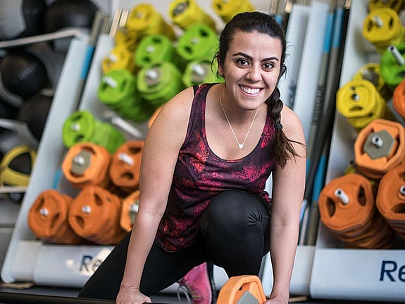 Sonia i träningskläder intill gymutrustning