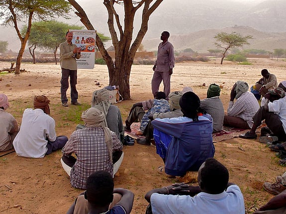 Grupp sitter under träd och utbildas i folkrätt och skydd