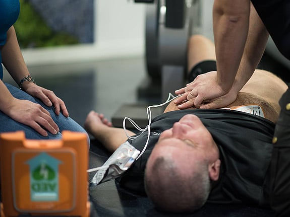 Man har fått hjärtstopp och får hjälp med hjärt-lungräddning, HLR, med hjärtstartare.