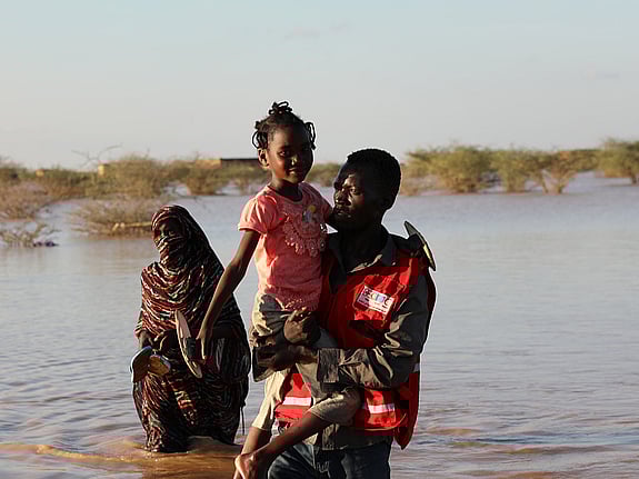 Mamma och barn går genom vattenmassor