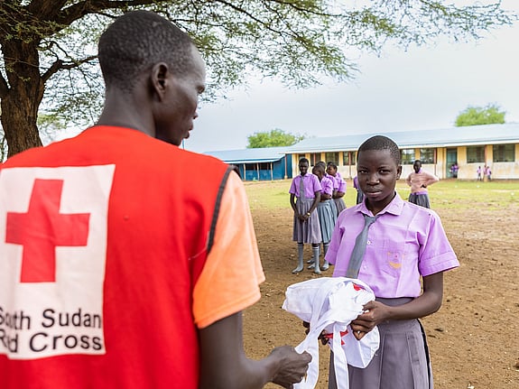Röda Korset volontär delar ut mensskydd i skola