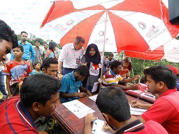Grupp med människor i samtal under solskydd