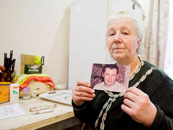 Kvinna med foto på saknad anhörig