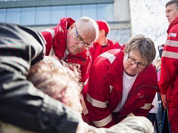 Man och kvinna i Röda Korset-jackor