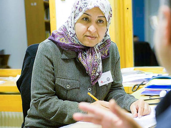 Kvinna hjälper papperslös man med vårdförmedling