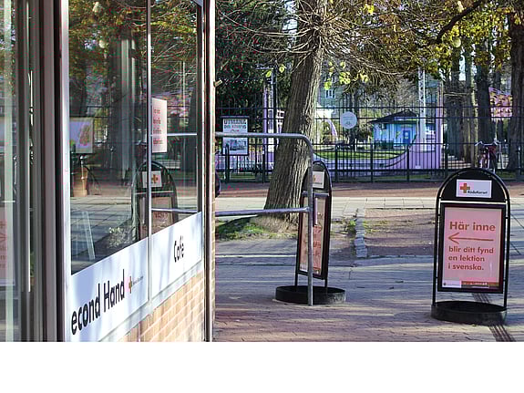 butiksfasad, i förgrunden syns några ballonger med röda korsets logga på