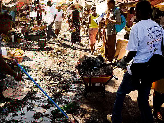 Människor rengör förorenad gata