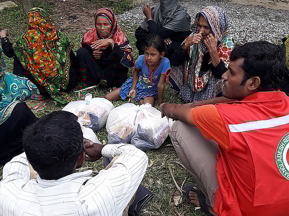 Volontär och kvinnor i Cox's Bazar sitter i cirkel