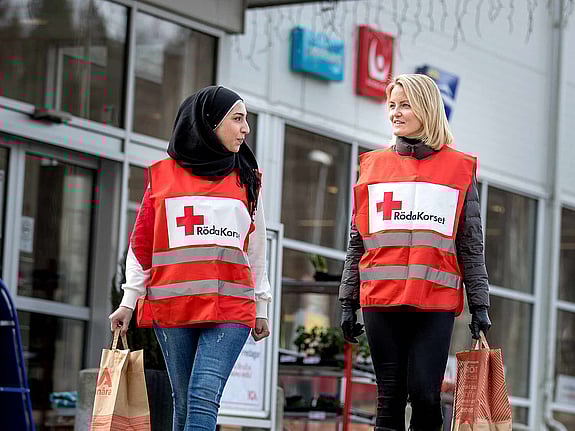 Två volontärer med matkassar