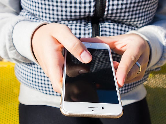 Händer som håller i en mobil