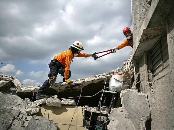 Volontärer letar i rasmassor på Haiti
