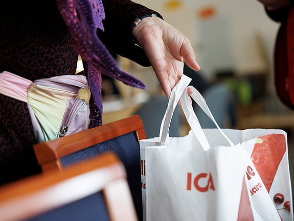 Hand som håller i en ICA-kasse.