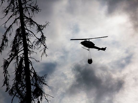 Helikopter flyger med vatten