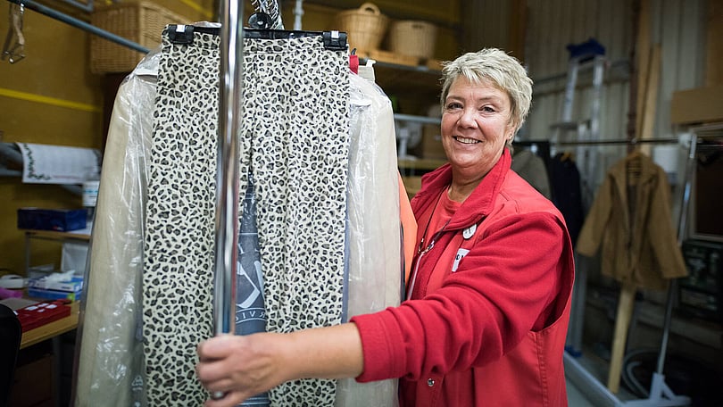 kvinna-flyttar-och-sorterar-kläder-i-second-hand-butik