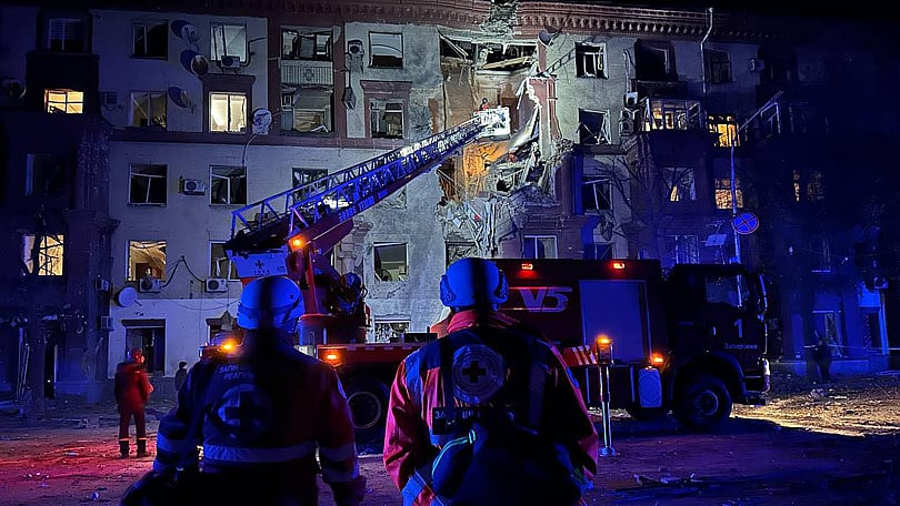 Volontärer hjälper vid beskjuten byggnad.