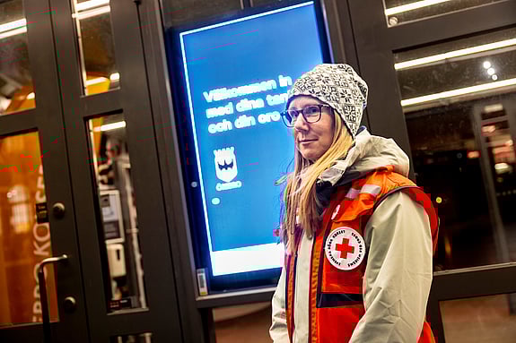Rödakorsaren Petra Åhlund, som leder första hjälpen-gruppen, tittar in i kameran. Hon står utomhus och har på sig en rödakorsväst.