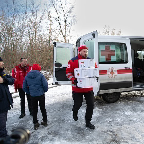 Man drar gummibåt med människor på översvämmad gata