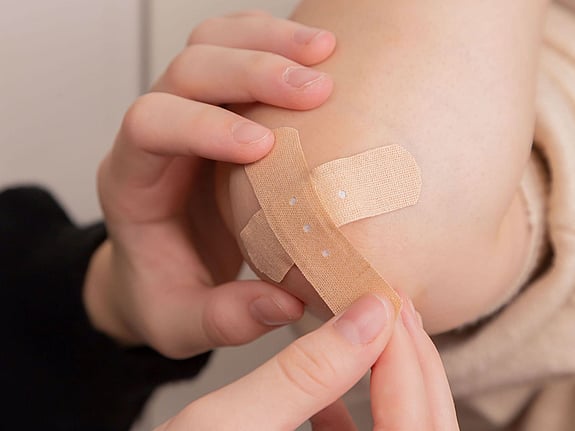 Plåster fästs på en sårskada