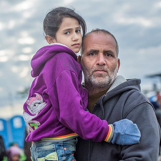 Asylsökande man kramar dotter i lila tröja